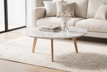 Load image into Gallery viewer, Round marble coffee table in a living room with a beige sofa and decorative items.